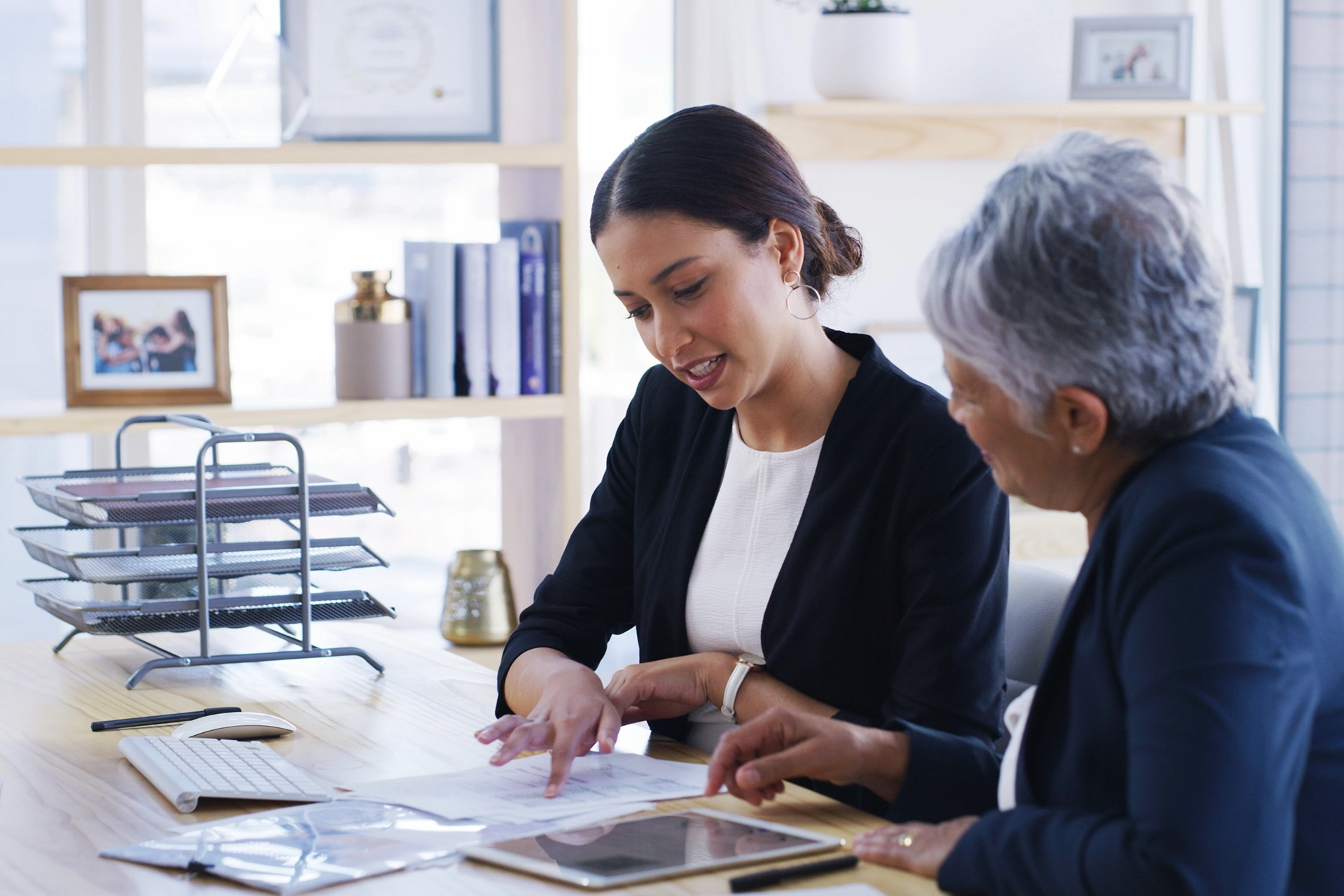 Woman explaining documents to older woman